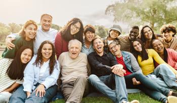 Fifteen people of all races and from adolescence to old age, smiling